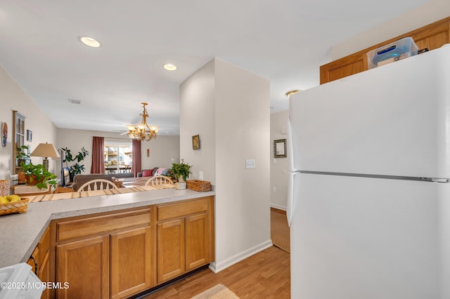 1090 Radio Rd Unit 12, Little Egg Harbor, NJ 08087 - kitchen with freestanding refrigerator, a chandelier, light wood-style flooring, light countertops, and recessed lighting