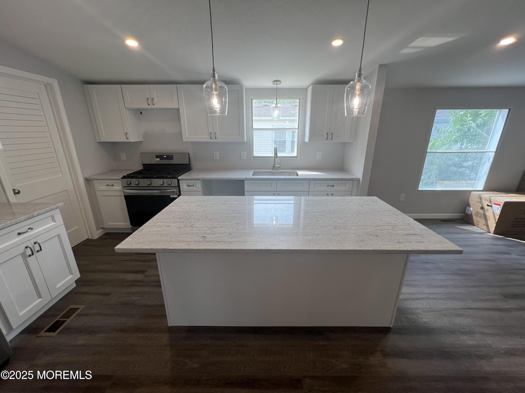 1991 Rte 37 Unit 177, Toms River, NJ 08757 - kitchen featuring stainless steel gas stove, white cabinetry, a center island, a sink, and light stone counters