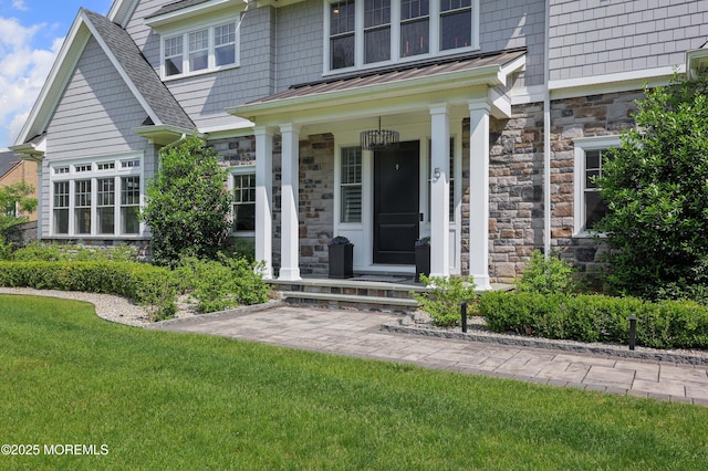 5 Buchop Ln, Red Bank, NJ 07701 - doorway to property with stone siding, a standing seam roof, a porch, a metal roof, and a lawn