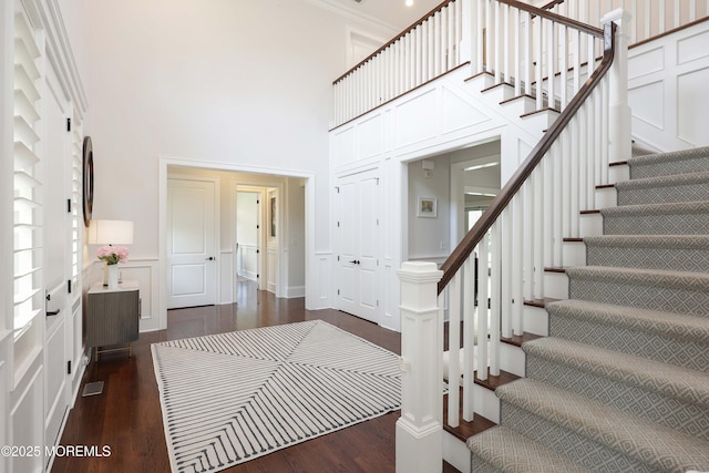 5 Buchop Ln, Red Bank, NJ 07701 - foyer entrance with stairs, a towering ceiling, dark wood-style flooring, a decorative wall, and a wainscoted wall