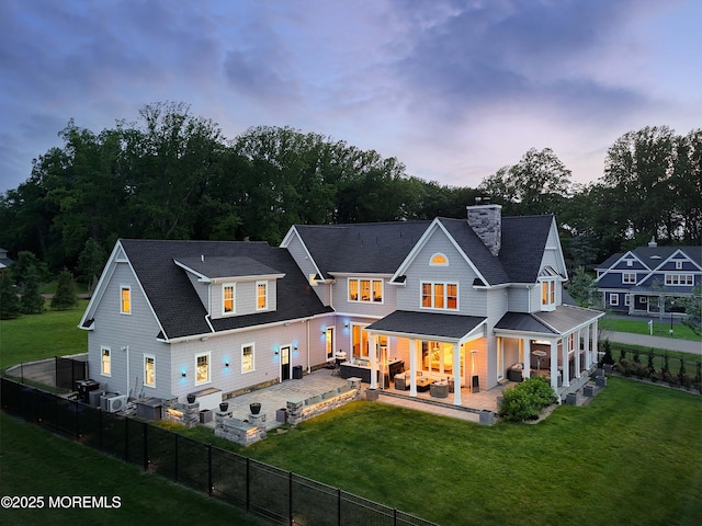 5 Buchop Ln, Red Bank, NJ 07701 - back of property at dusk with a chimney, a fenced backyard, a patio area, and roof with shingles