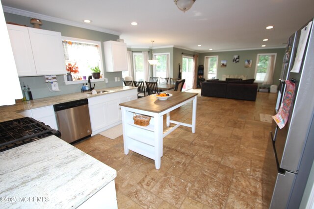 132 Sloop Rd, Manahawkin, NJ 08050 - kitchen with appliances with stainless steel finishes, crown molding, open floor plan, a sink, and white cabinetry
