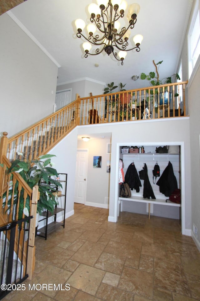 132 Sloop Rd, Manahawkin, NJ 08050 - stairway featuring a chandelier, stone tile floors, a high ceiling, crown molding, and baseboards