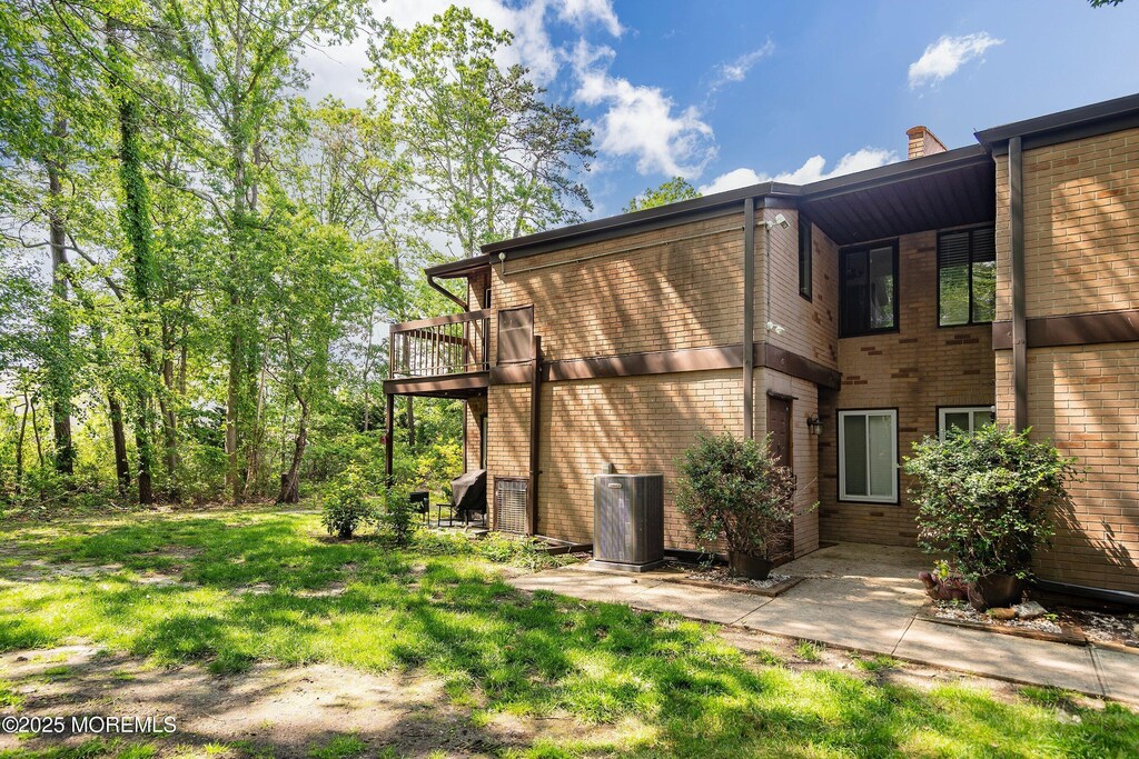 117 Northrup Dr, Brick, NJ 08724 - view of property exterior with central AC unit, brick siding, a lawn, and a chimney