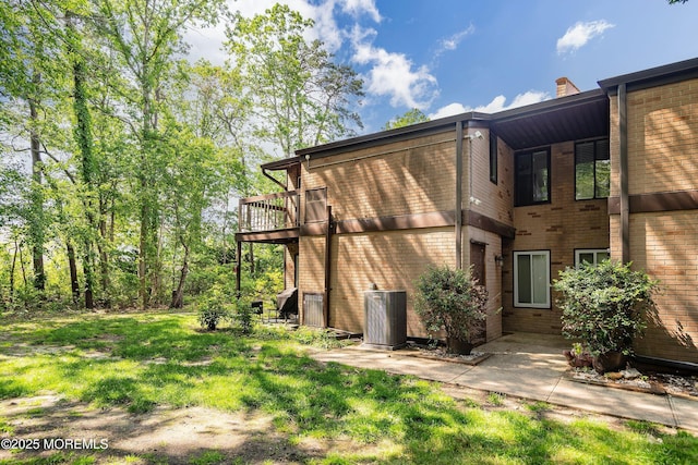 117 Northrup Dr, Brick, NJ 08724 - view of property exterior with central AC unit, brick siding, a lawn, and a chimney