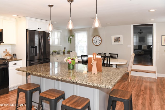 202 Main St, Matawan, NJ 07747 - kitchen with stainless steel appliances, light wood-style floors, white cabinets, recessed lighting, and light stone counters