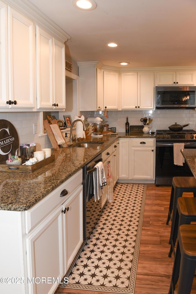 202 Main St, Matawan, NJ 07747 - kitchen featuring appliances with stainless steel finishes, a sink, backsplash, white cabinets, and recessed lighting