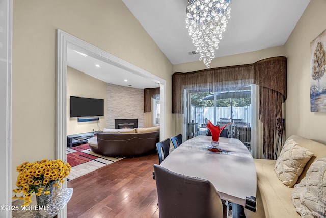 152 Redpine Loop, Old Bridge, NJ 08857 - dining space featuring vaulted ceiling, a stone fireplace, wood finished floors, and a chandelier