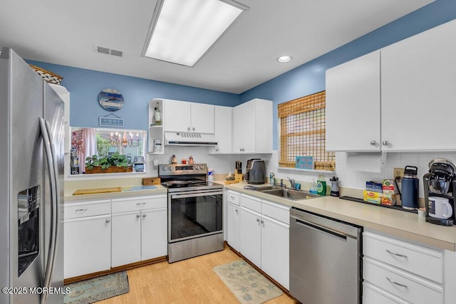 551 Petunia Ln N, Whiting, NJ 08759 - kitchen with stainless steel appliances, under cabinet range hood, white cabinetry, light countertops, and recessed lighting