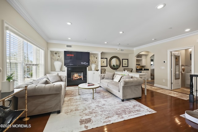 14 White Oak Ln, Aberdeen, NJ 07747 - living area featuring arched walkways, crown molding, wood finished floors, a glass covered fireplace, and recessed lighting