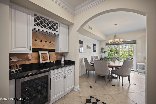 14 White Oak Ln, Aberdeen, NJ 07747 - dining room with wine cooler, bar area, a chandelier, crown molding, and arched walkways