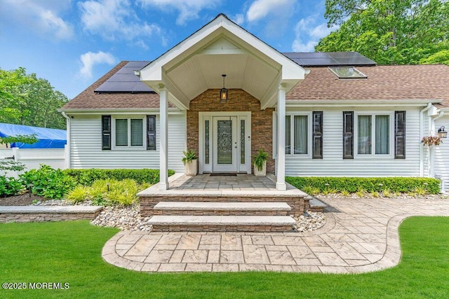 145 Docare Rd, Jackson, NJ 08527 - view of exterior entry featuring solar panels, roof with shingles, and a yard