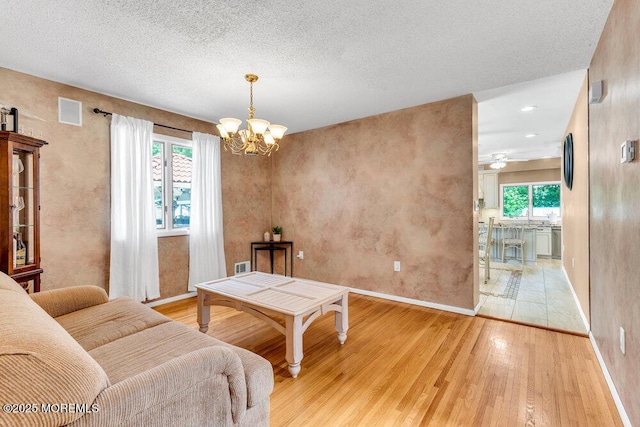 145 Docare Rd, Jackson, NJ 08527 - living area featuring light wood-type flooring, a chandelier, baseboards, a textured ceiling, and a ceiling fan