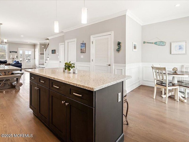 29 7th Ave Unit B, Seaside Heights, NJ 08751 - kitchen with ornamental molding, wood finished floors, pendant lighting, a breakfast bar, and wainscoting