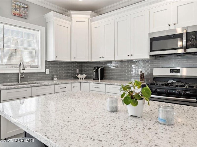 29 7th Ave Unit B, Seaside Heights, NJ 08751 - kitchen featuring appliances with stainless steel finishes, a sink, ornamental molding, backsplash, and white cabinetry