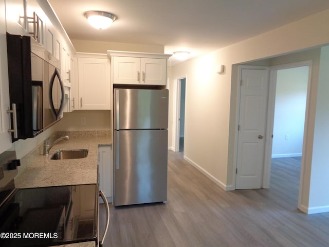 5D Wintergreen Ln, Whiting, NJ 08759 - kitchen featuring appliances with stainless steel finishes, a sink, wood finished floors, light stone counters, and white cabinetry