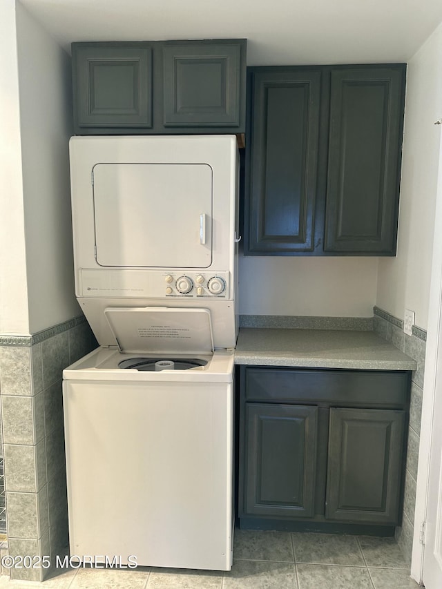 45 Ocean Ave Unit 8D, Monmouth Beach, NJ 07750 - laundry area featuring stacked washer / drying machine, cabinet space, light tile patterned floors, and tile walls