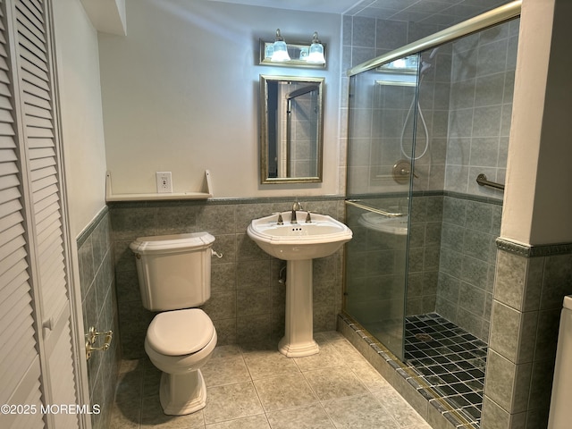 45 Ocean Ave Unit 8D, Monmouth Beach, NJ 07750 - bathroom featuring tile walls, toilet, a stall shower, a closet, and tile patterned flooring