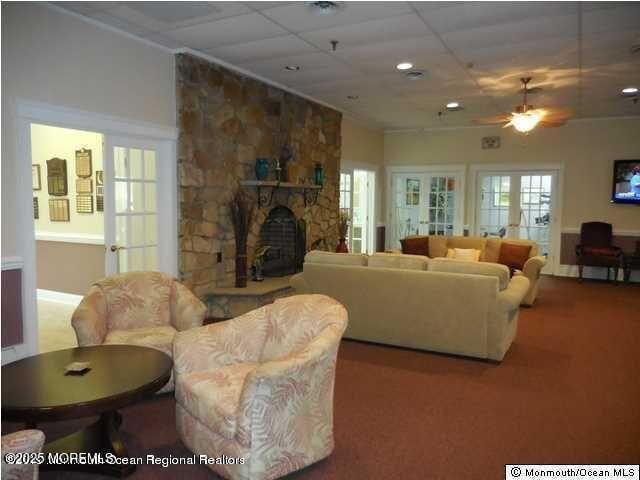5 Lodge Ct, Brick, NJ 08724 - carpeted living room featuring a stone fireplace, ceiling fan, baseboards, a drop ceiling, and recessed lighting