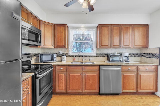 5 Lodge Ct, Brick, NJ 08724 - kitchen with stainless steel appliances, a sink, brown cabinetry, light stone counters, and decorative backsplash