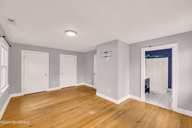 645 Campbell Ave, Long Branch, NJ 07740 - unfurnished bedroom featuring baseboards, light wood-style floors, multiple closets, and ensuite bath