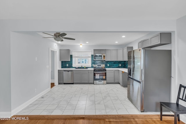 645 Campbell Ave, Long Branch, NJ 07740 - kitchen with appliances with stainless steel finishes, gray cabinets, a sink, light countertops, and light marble finish flooring