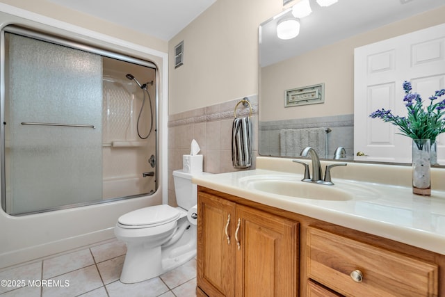 654 Fairview Ln, Forked River, NJ 08731 - full bath featuring tile patterned floors, vanity, toilet, tile walls, and bath / shower combo with glass door