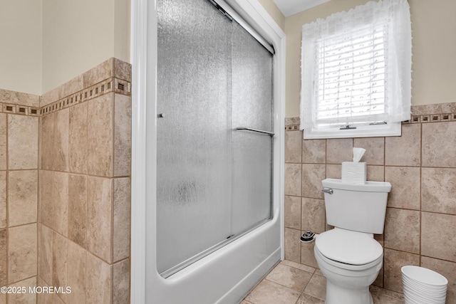 654 Fairview Ln, Forked River, NJ 08731 - full bathroom with tile walls, toilet, a wainscoted wall, tile patterned floors, and combined bath / shower with glass door
