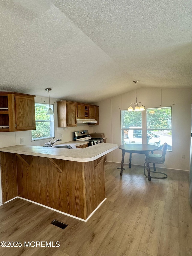 11 B Trail Trail, Brick, NJ 08724 - kitchen with stainless steel range, brown cabinets, light wood-style flooring, a textured ceiling, and light countertops