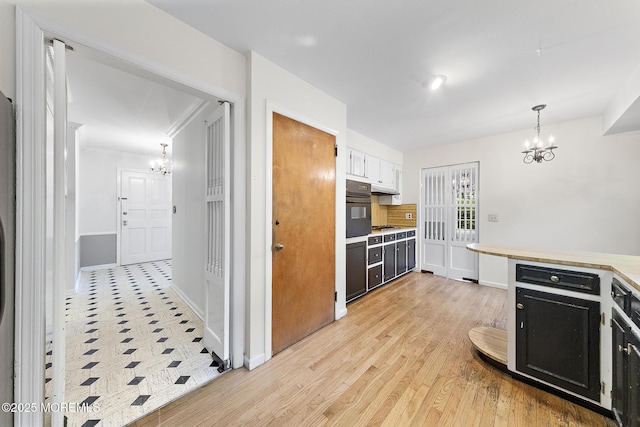 23 Fox Hill Dr, Little Silver, NJ 07739 - kitchen featuring a chandelier, black oven, dark cabinetry, light countertops, and ornamental molding