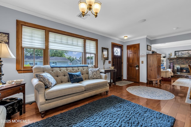 711 Hardean Rd, Brick, NJ 08724 - living room featuring a chandelier, hardwood / wood-style flooring, ornamental molding, a brick fireplace, and baseboard heating