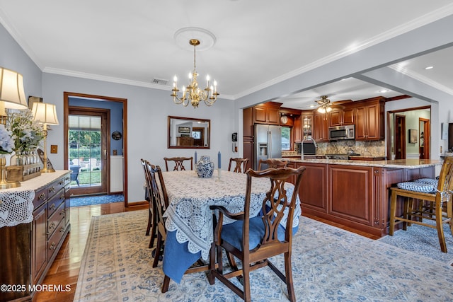 711 Hardean Rd, Brick, NJ 08724 - dining space featuring a chandelier, light wood-style flooring, baseboards, a ceiling fan, and crown molding