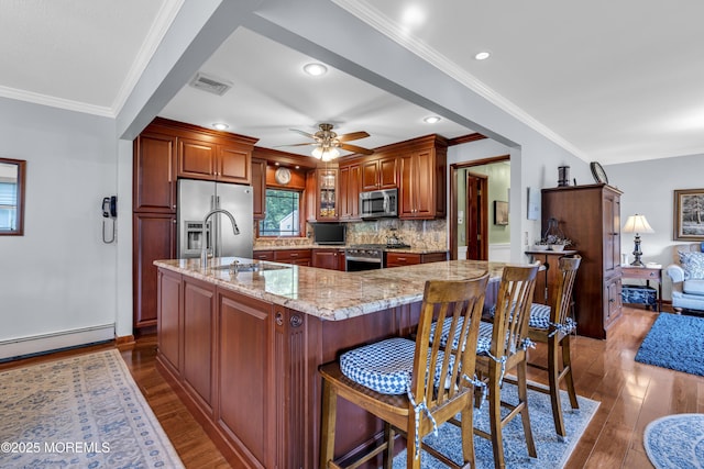 711 Hardean Rd, Brick, NJ 08724 - kitchen featuring stainless steel appliances, a sink, dark wood-style flooring, a baseboard radiator, and ornamental molding