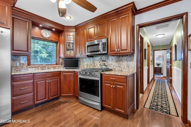 711 Hardean Rd, Brick, NJ 08724 - kitchen featuring appliances with stainless steel finishes, wood finished floors, ceiling fan, light stone counters, and glass insert cabinets