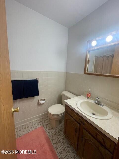 1301 SW Central Ave Unit B8, Seaside Park, NJ 08752 - full bathroom with tile walls, vanity, toilet, wainscoting, and a shower with shower curtain
