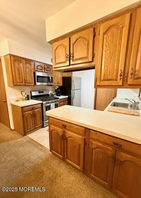 1301 SW Central Ave Unit B8, Seaside Park, NJ 08752 - kitchen featuring stainless steel appliances, brown cabinets, a peninsula, and light countertops