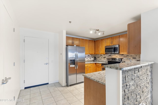 1 Carriage City Plz Unit 711, Rahway, NJ 07065 - kitchen with appliances with stainless steel finishes, tasteful backsplash, a peninsula, and brown cabinetry