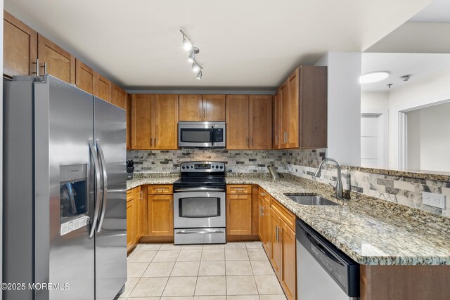 1 Carriage City Plz Unit 711, Rahway, NJ 07065 - kitchen with appliances with stainless steel finishes, light tile patterned floors, brown cabinets, tasteful backsplash, and light stone countertops