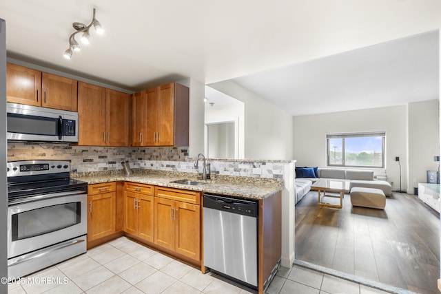 1 Carriage City Plz Unit 711, Rahway, NJ 07065 - kitchen with stainless steel appliances, open floor plan, brown cabinets, and tasteful backsplash