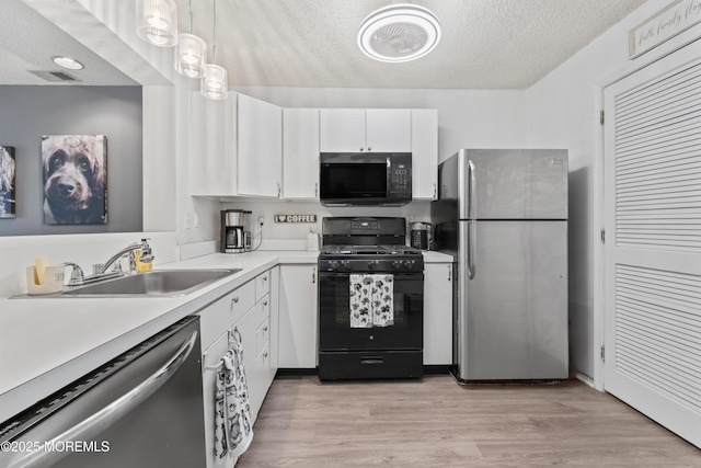 70 Madison Ct, Tinton Falls, NJ 07712 - kitchen with stainless steel appliances, light countertops, white cabinetry, a textured ceiling, and light wood finished floors