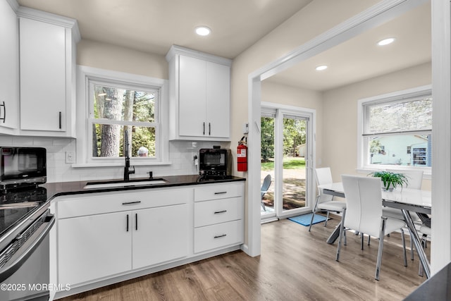 29 Bowie Dr, Whiting, NJ 08759 - kitchen featuring stainless steel electric range oven, dark countertops, tasteful backsplash, wood finished floors, and white cabinetry