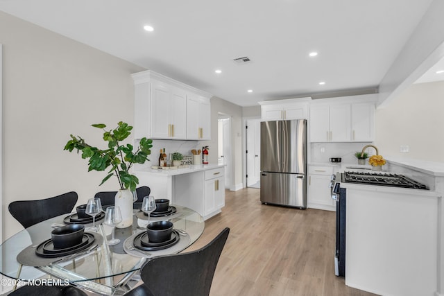 882 Radio Rd, Little Egg Harbor, NJ 08087 - kitchen with stainless steel appliances, light countertops, white cabinetry, recessed lighting, and light wood-style floors