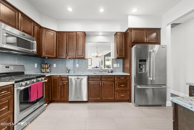 24 Birmingham Ln, Monroe, NJ 08831 - kitchen featuring stainless steel appliances, backsplash, a chandelier, light stone countertops, and a sink