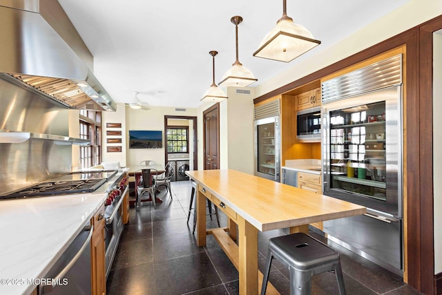425 E Ave, Bay Head, NJ 08742 - kitchen with wall chimney exhaust hood, premium appliances, wine cooler, washer and clothes dryer, and pendant lighting