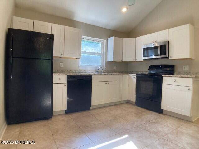 273 Stuart St, Howell, NJ 07731 - kitchen with black appliances, white cabinets, lofted ceiling, light tile patterned flooring, and a sink