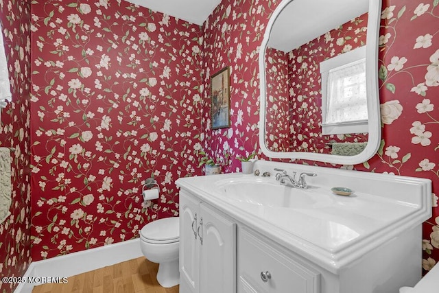 116 Curtis Ave, Manasquan, NJ 08736 - half bathroom with wallpapered walls, wood finished floors, toilet, vanity, and baseboards