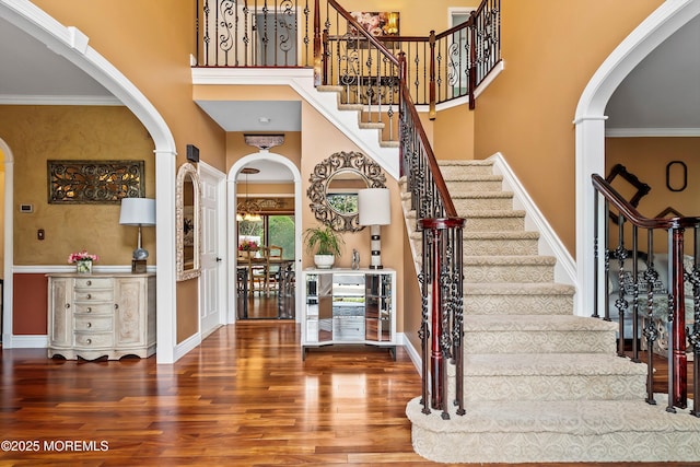 626 Windcrest Ct, Brick, NJ 08724 - entrance foyer with arched walkways, wood finished floors, stairs, crown molding, and a towering ceiling