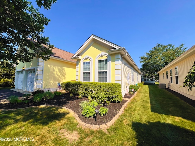 16 Woodstock Ct, Jackson, NJ 08527 - view of side of property featuring a yard, an attached garage, and stucco siding