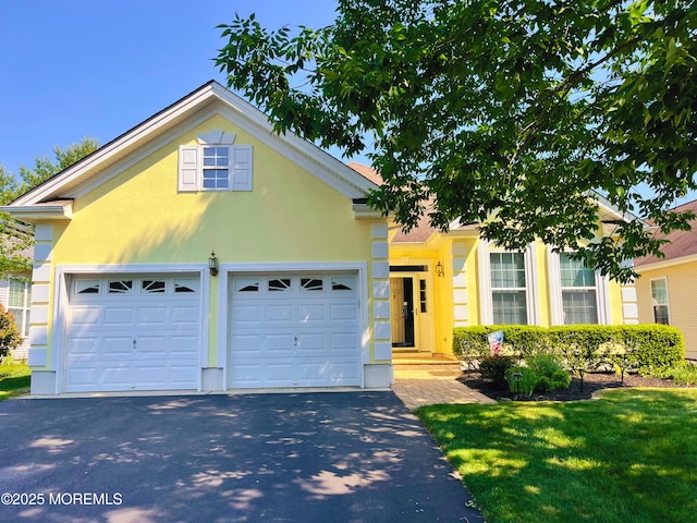 16 Woodstock Ct, Jackson, NJ 08527 - view of front of home with asphalt driveway, a garage, stucco siding, and a front yard