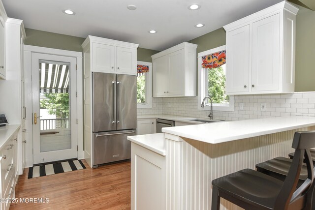 51 Clay St, Fair Haven, NJ 07704 - kitchen featuring stainless steel appliances, light wood finished floors, a peninsula, white cabinets, and recessed lighting